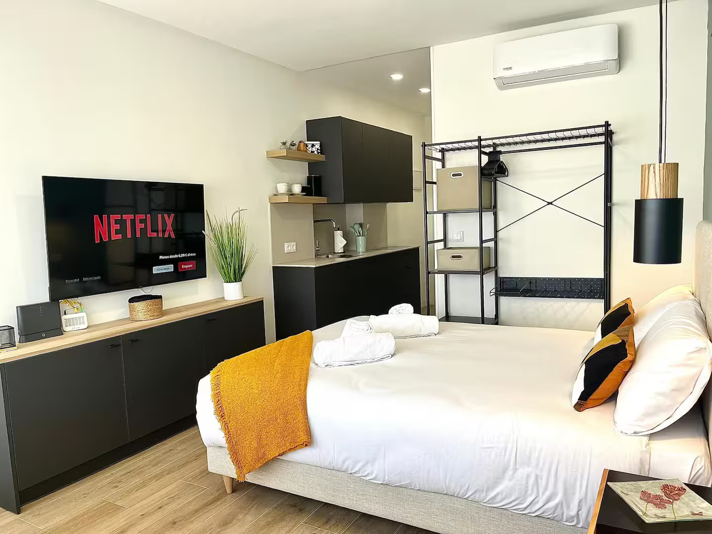 Espacio multifuncional con cama, cocina y zona de entretenimiento
