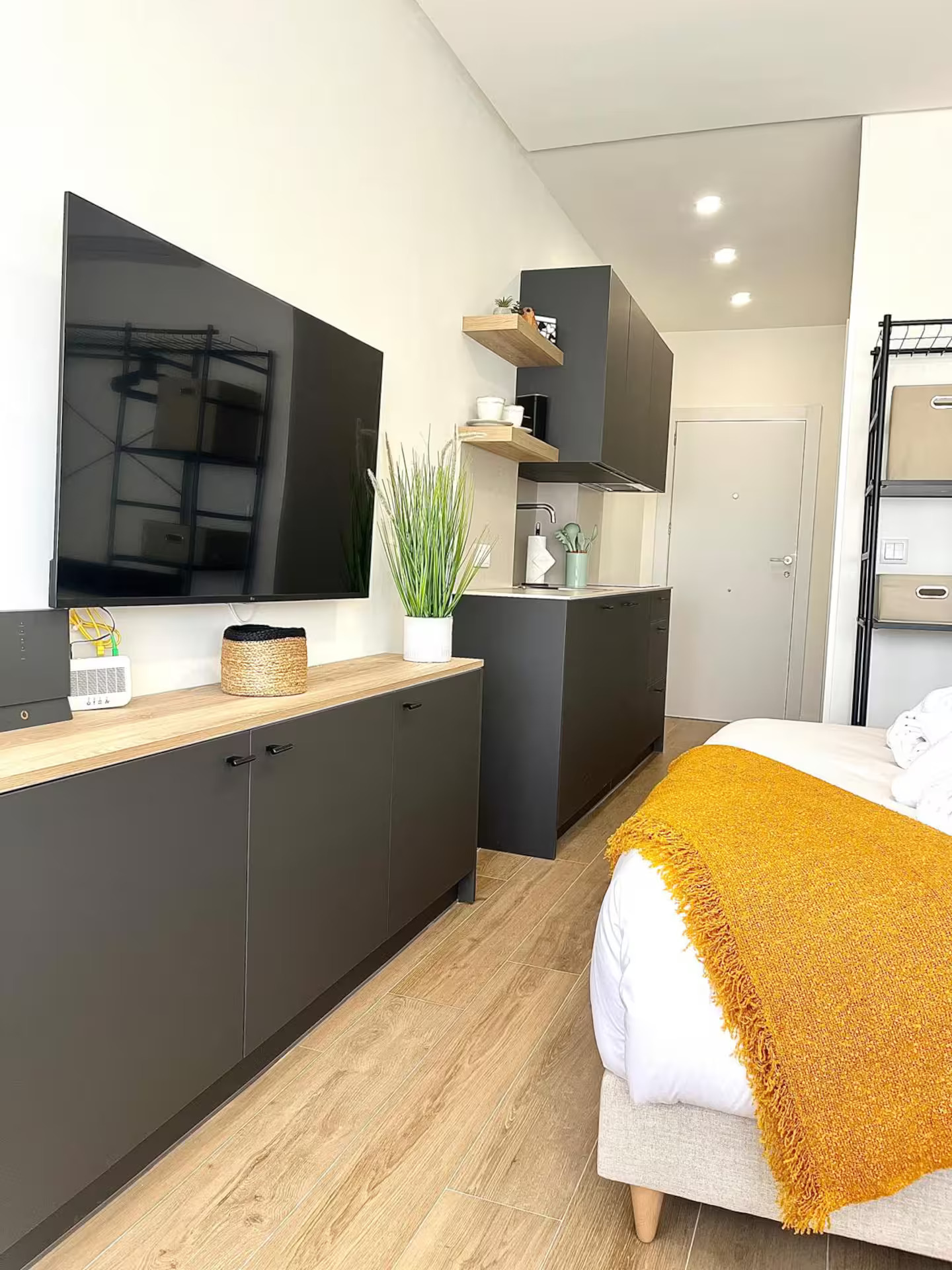 Salón moderno con televisor de pantalla plana y mueble negro con superficie de madera clara